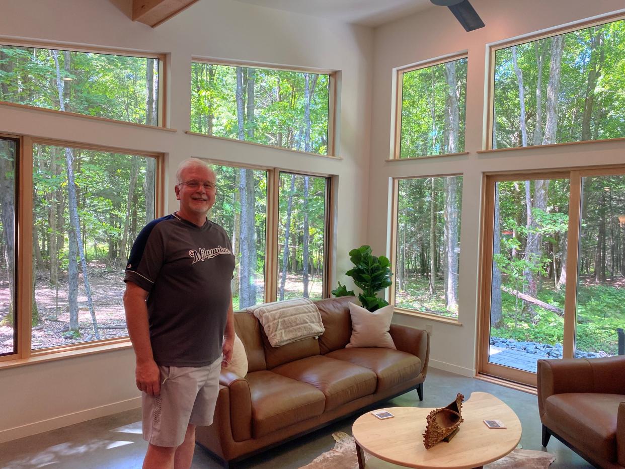 Randy Bangs stands in the living room of his luxury rental cabin Owl Ridge Cabin. He designed the cabin to be a getaway for solo guests and couples, with an emphasis on a high-end, quiet and peaceful experience.