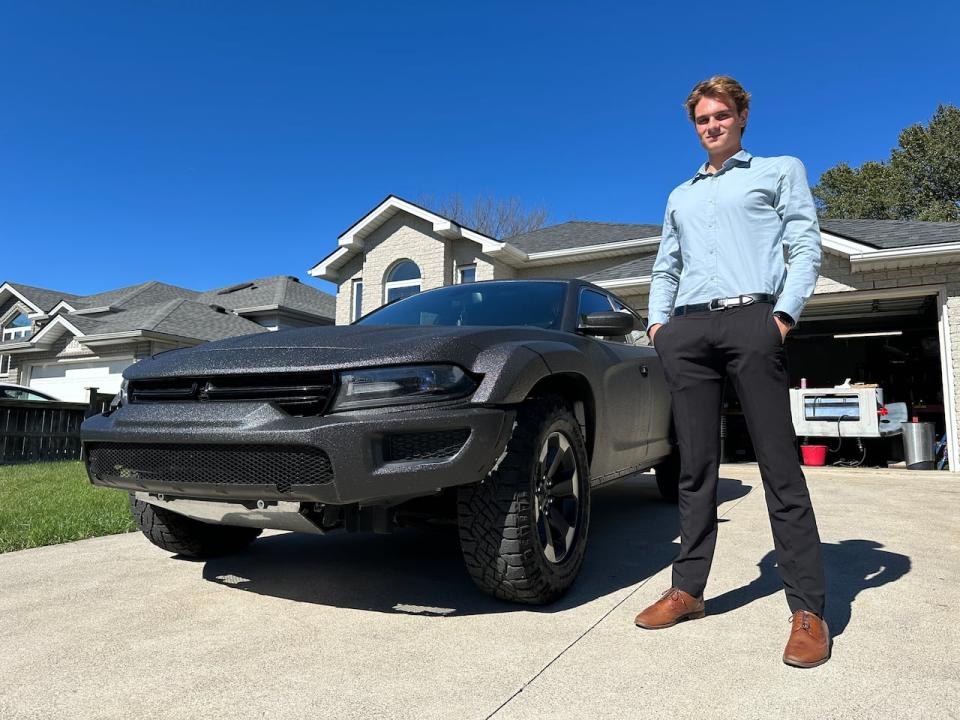 Lakeshore resident Lucas Kiewitz stands next to his personally customized Dodge Charger in his parents' driveway.