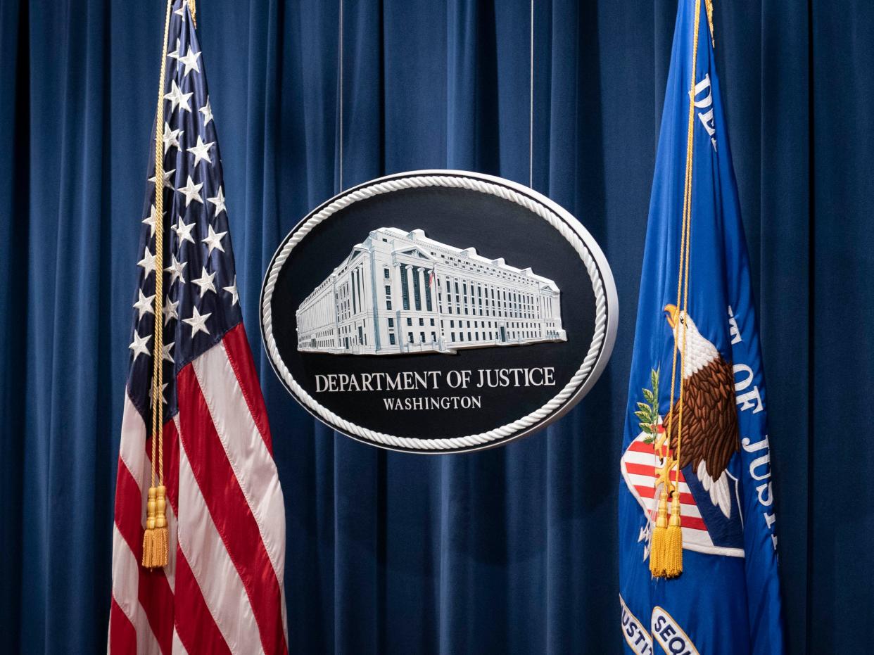 A sign for the Department of Justice is seen ahead of a news conference with Michael Sherwin, acting US attorney for the District of Columbia, and Steven D’Antuono, head of the Federal Bureau of Investigation (FBI) Washington field office, at the US Department of Justice in Washington, DC, on 12 January 2021 ((POOL/AFP via Getty Images))