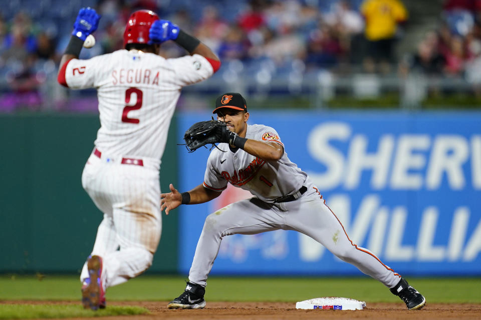 Baltimore Orioles shortstop Richie Martin, right, prepares to tag out Philadelphia Phillies' Jean Segura at second base on a double play hit into by Bryce Harper during the third inning of an interleague baseball game, Wednesday, Sept. 22, 2021, in Philadelphia. Harper was out at first on the play. (AP Photo/Matt Slocum)