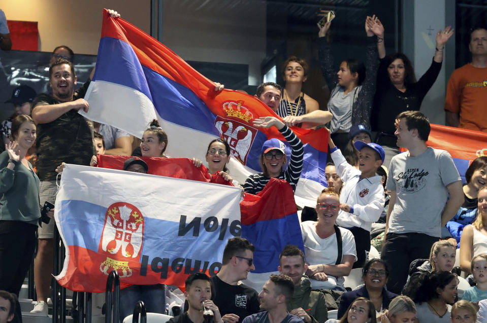 Supporters of Serbia's Novak Djokovic cheer him on during his first round match against Germany's Jan-Lennard Struff at the Australian Open tennis championship in Melbourne, Australia, Monday, Jan. 20, 2020. (AP Photo/Lee Jin-man)