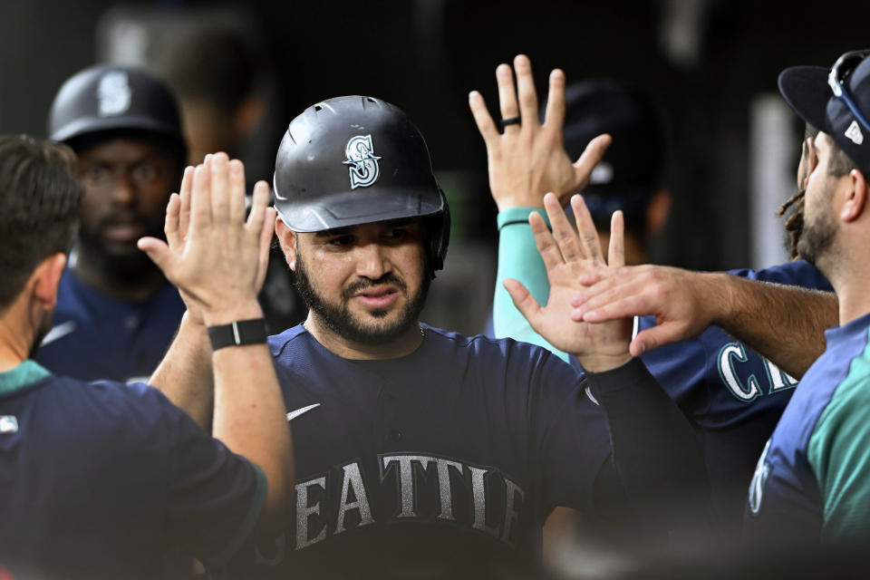 Seattle Mariners' Eugenio Suarez is congratulated after scoring on a sacrifice fly by Taylor Trammell against the Baltimore Orioles in the third inning of a baseball game Tuesday, May 31, 2022, in Baltimore. (AP Photo/Gail Burton)