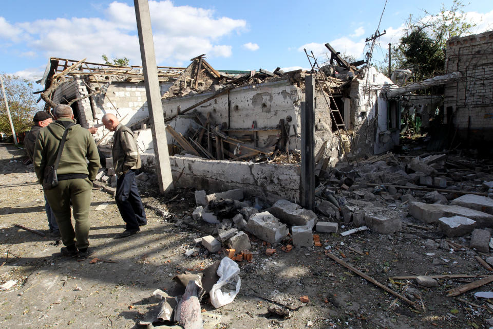 Männer stehen vor einem Haus, das bei einem russischen Raketenangriff in Obuchiwka zerstört wurde (Bild: --/Ukrinform/dpa)