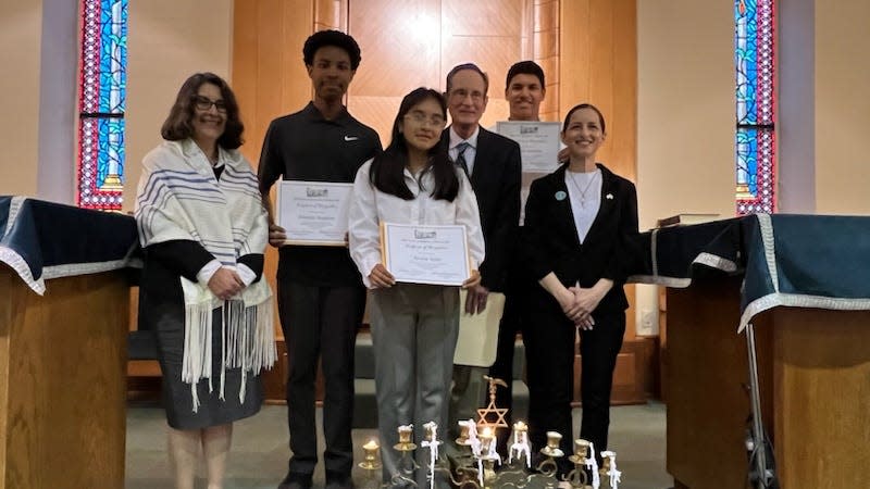 The three winners of Beth Israel's essay contest. From left are Rabbi Ruth Smith; Diontay Duppins, second place winner; Briana Ayala, third place winner; Andrew Karten, co-chair of the Holocaust Program; Daniel McBride, first place winner; and Jaimi Hall, co-chair of the Holocaust program.