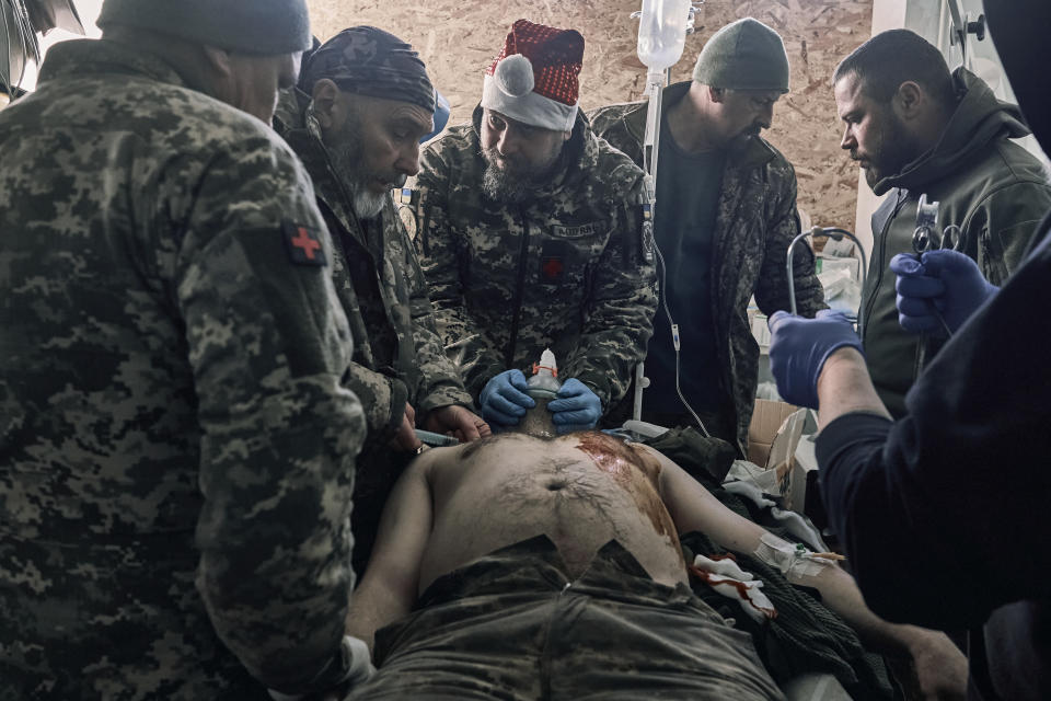 An injured Ukrainian soldier receives first aid at a hospital in Donetsk region, Ukraine, Monday, Dec. 19, 2022. (AP Photo/LIBKOS)