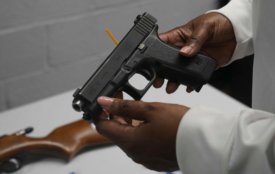 FILE - In this May 22, 2021, file photo a handgun from a collection of illegal guns is reviewed during a gun buyback event in Brooklyn, N.Y. Gun violence is on the rise across the country and law enforcement agencies are struggling with how to manage the spikes, especially in cities. The federal government has stepped in with strike forces and other measures help to stop the sale of illegal weapons. (AP Photo/Bebeto Matthews, FIle)