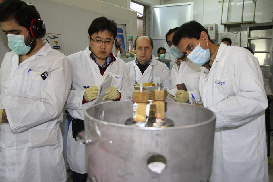 FILE - International Atomic Energy Agency inspectors and Iranian technicians prepare to cut the connections between the twin cascades for 20% uranium enrichment at the Natanz nuclear site near Natanz, Iran, Jan. 20, 2014. A new underground facility at the Natanz enrichment site may put centrifuges beyond the range of a massive so-called “bunker buster” bomb earlier developed by the U.S. military, according experts and satellite photos analyzed by The Associated Press in May 2023. (Kazem Ghane/IRNA via AP, File)