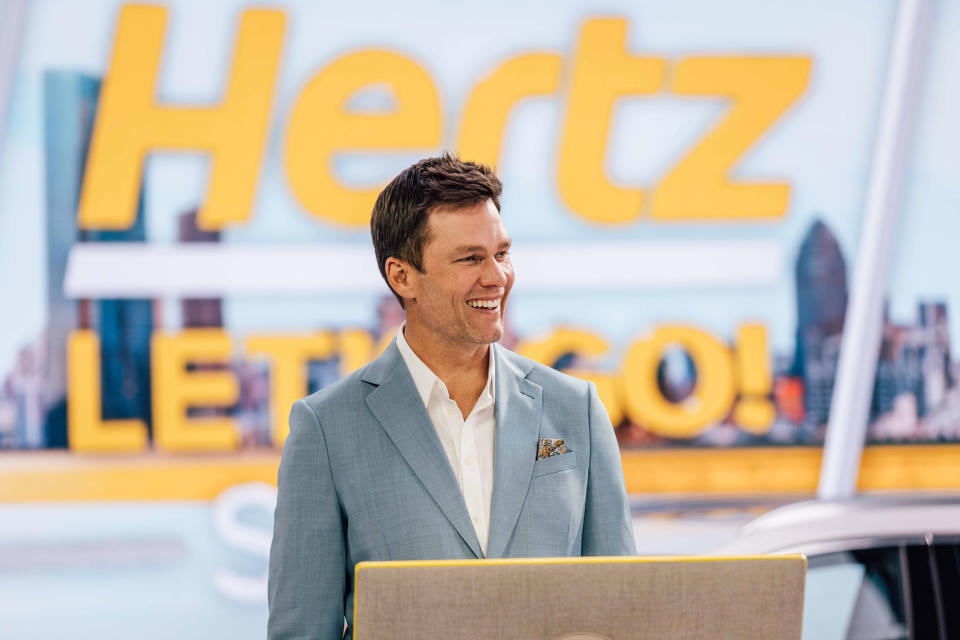 Tom Brady appears smiling on the set of a new Hertz commercial