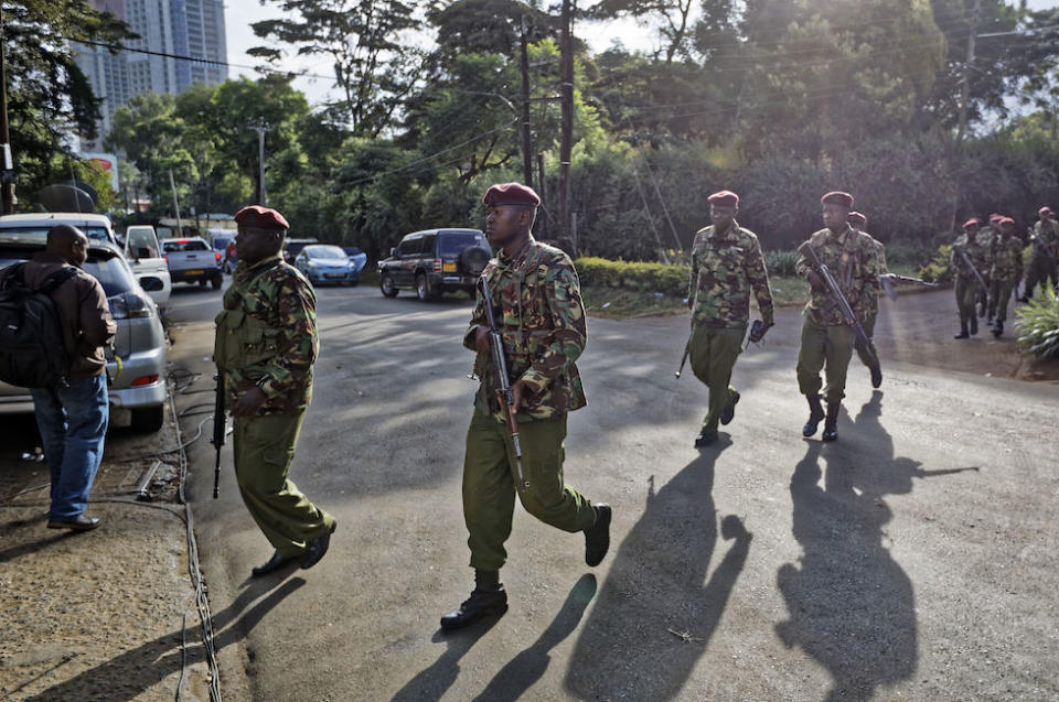 Security forces walk to the scene as continued blasts and gunfire could be heard early on Wednesday (Picture: AP)