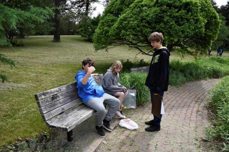 Kyleigh Dishman, Kole Herline and Camden Trimble, seventh grade students at Northwestern Middle School, compare what they found during a nature scavenger hunt at Leila Arboretum on Thursday, June 2, 2022 in Battle Creek, Mich.