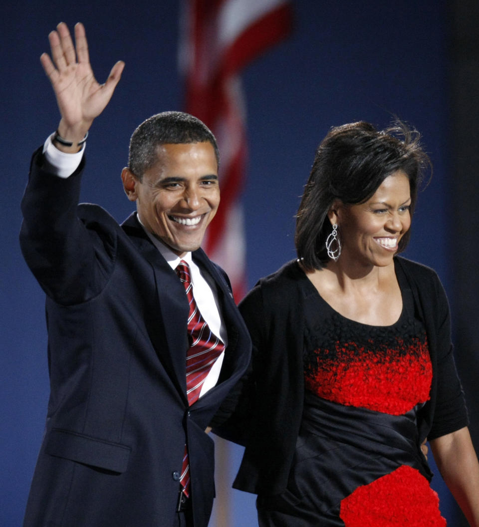 FILE - In this Nov. 4, 2008 file photo, then-President-elect Barack Obama and his wife Michelle Obama, wearing a Narciso Rodriguez dress, acknowledge the crowd after he delivered his victory speech at his election night party at Grant Park in Chicago. Curators at the National Archives have culled their collection in search of some of the great signatures of history. A special exhibit opening Friday includes the personal marks of figures that include Thomas Jefferson, Frank Sinatra, Jackie Robinson, Adolf Hitler and Saddam Hussein, along with important documents from history. For the first time, the black dress worn by Michelle Obama on the night of the 2008 election is going on display. It was designed by Narcisco Rodriguez. (AP Photo/Pablo Martinez Monsivais, File)