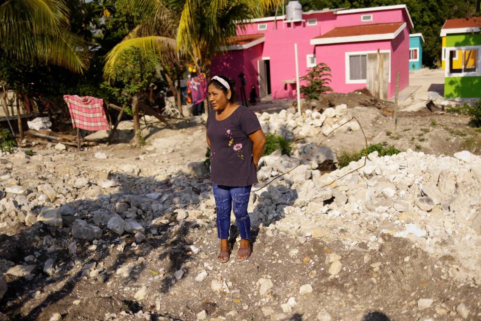 Rosario Jimenez stands in front of her new house after being relocated due to the construction of section 1 of the new Mayan Train route, in the town of Haro, Mexico, on May 12, 2022. Jimenez says she was upset when her house was demolished, but is happy she has been relocated into a newly built home further back from the train tracks.<span class="copyright">Jose Luis Gonzalez—Reuters</span>