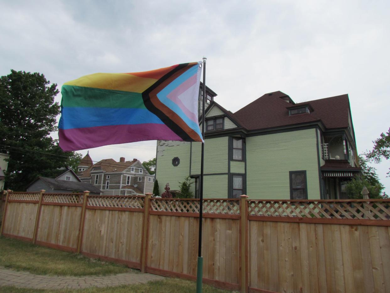 An LGBTQ+ Pride flag waving in the wind in the old Atrium Café garden on June 8, 2023. The local LGBTQ+ group Blue Water Allies will be opening a center in the building in July.