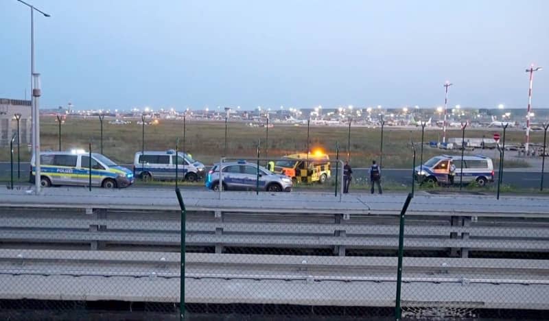 Police vehicles are parked on the tarmac at Frankfurt Airport. Air traffic has been temporarily halted due to a climate activist campaign. Mike Seeboth/TNN/dpa