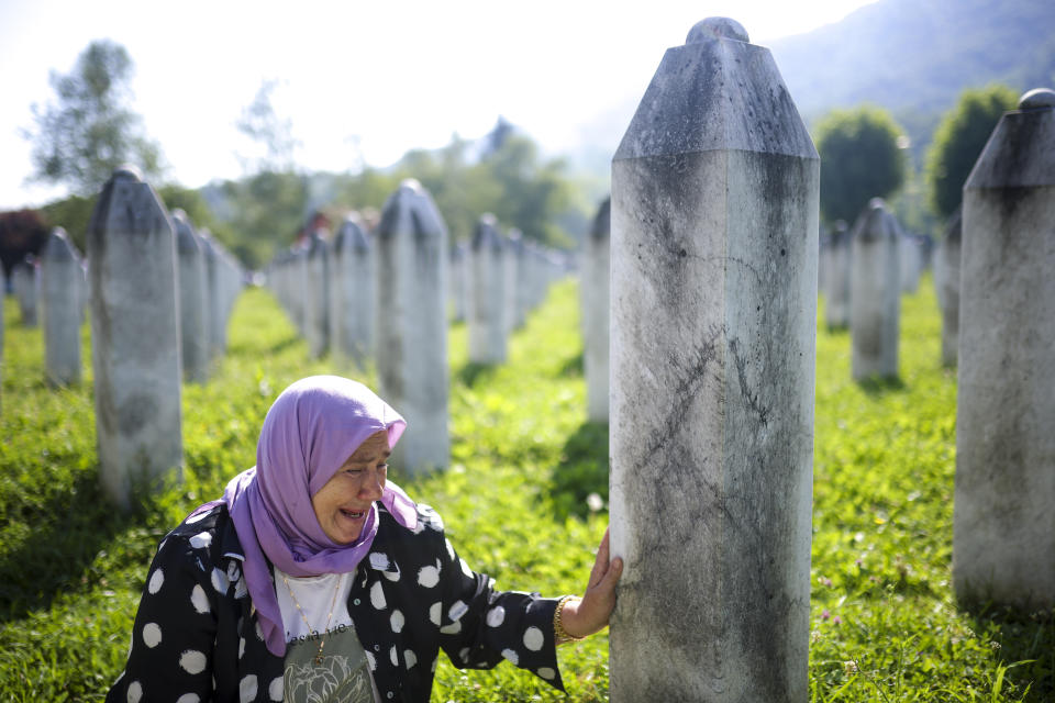 Rukija Besic mourns next to the graves of her husband and son, victims of the Srebrenica genocide, at the Srebrenica Memorial Centre, in Potocari, Bosnia, Thursday, July 11, 2024. Thousands gathered in the eastern Bosnian town of Srebrenica to commemorate the 29th anniversary on Monday of Europe's only acknowledged genocide since World War II. (AP Photo/Armin Durgut)