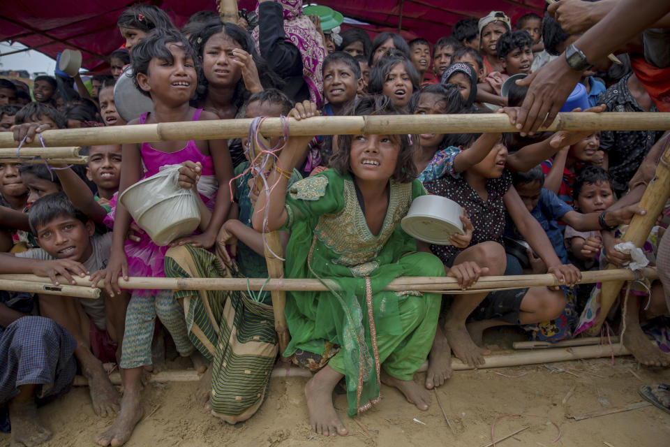 FILE - Rohingya Muslim children refugees, who crossed over from Myanmar into Bangladesh, wait squashed against each other to receive food handouts distributed to children and women by a Turkish aid agency at Thaingkhali refugee camp, Bangladesh on Oct. 21, 2017. A dramatic story of survival and rescue off the western coast of Indonesia’s Aceh province has put the spotlight again on the plight of ethnic Rohingya Muslim refugees from Myanmar who make extremely dangerous voyages across the Indian Ocean to seek better lives. (AP Photo/Dar Yasin, File)