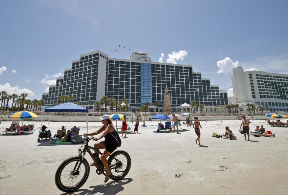 Beachgoers enjoy a sunny afternoon on Friday in front of the Hilton Daytona Beach Oceanfront Resort in Daytona Beach.