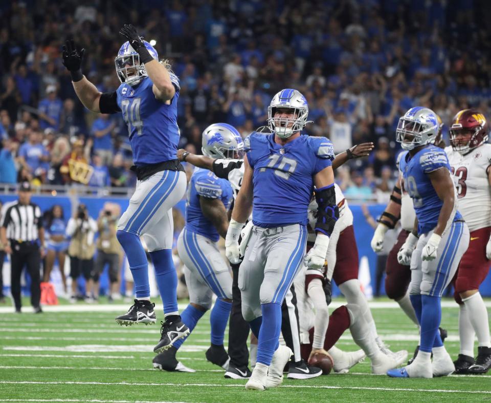 Sep 18, 2022; Detroit, Michigan, USA; Detroit Lions linebacker Alex Anzalone (34) and defensive end John Cominsky (79) celebrate a sack of Washington Commanders quarterback Carson Wentz (11) during second half action at Ford Field.