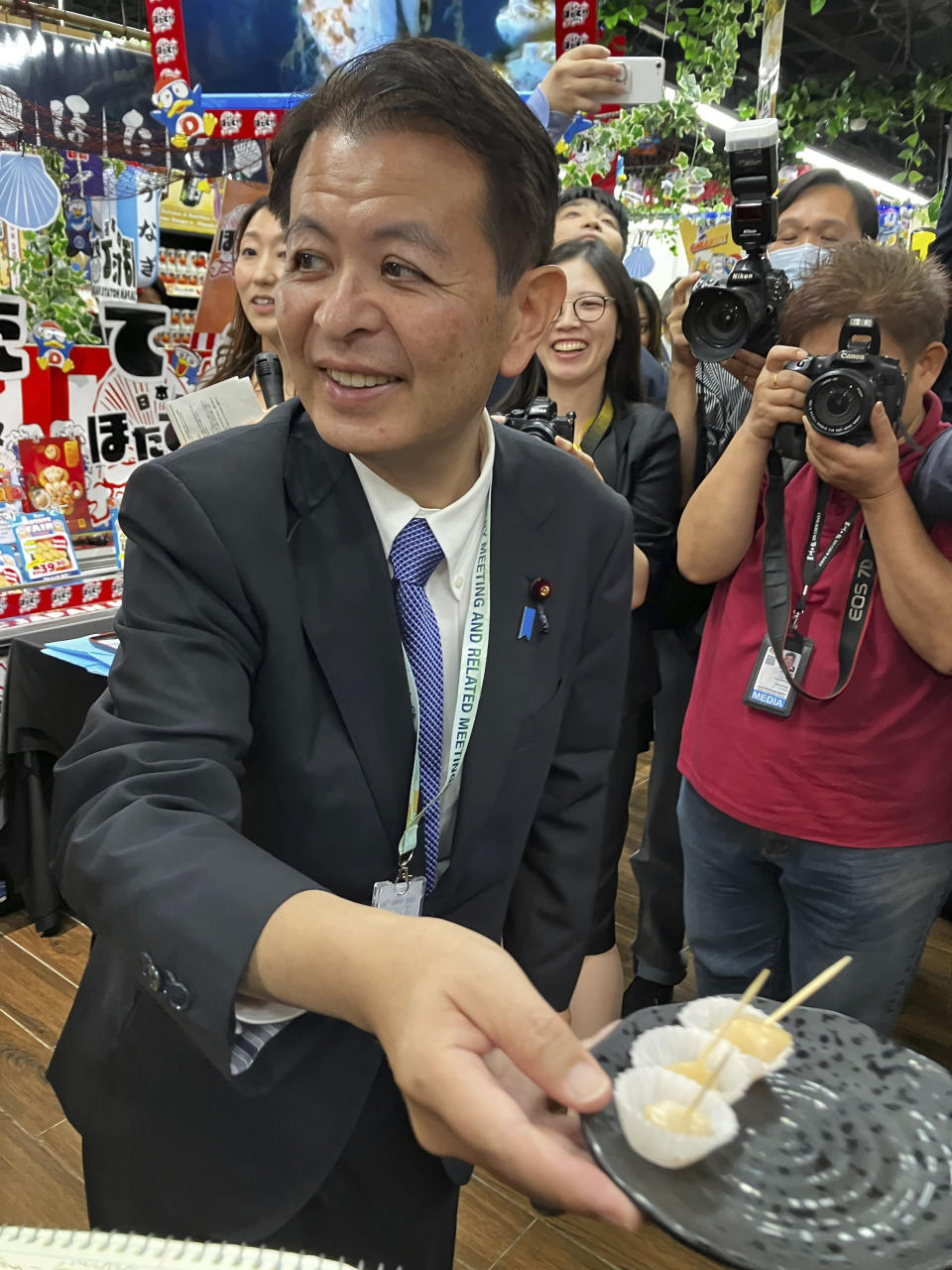 Japanese Agriculture Minister Ichiro Miyashita attends an event at Japanese store, Don Don Donki in Kuala Lumpur Wednesday, Oct. 4, 2023 to promote the safety and deliciousness of Japanese scallops to shoppers. Japan hopes to resolve the issue of China's ban on its seafood within the scope of the World Trade Organization ambit and will hold food fairs overseas to bolster seafood exports amid safety concerns over the release of treated water from the Fukushima Daiichi nuclear plant, Miyashita said Wednesday. (AP Photo/Eileen Ng)