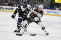 Minnesota Wild left wing Matt Boldy (12) fights for the puck against Colorado Avalanche center Andrew Cogliano (11) in the first period of an NHL hockey game Tuesday, April 9, 2024, in Denver. (AP Photo/Bart Young)