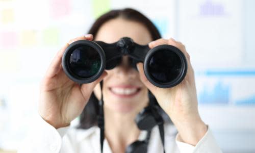 Woman looking in black professional binoculars