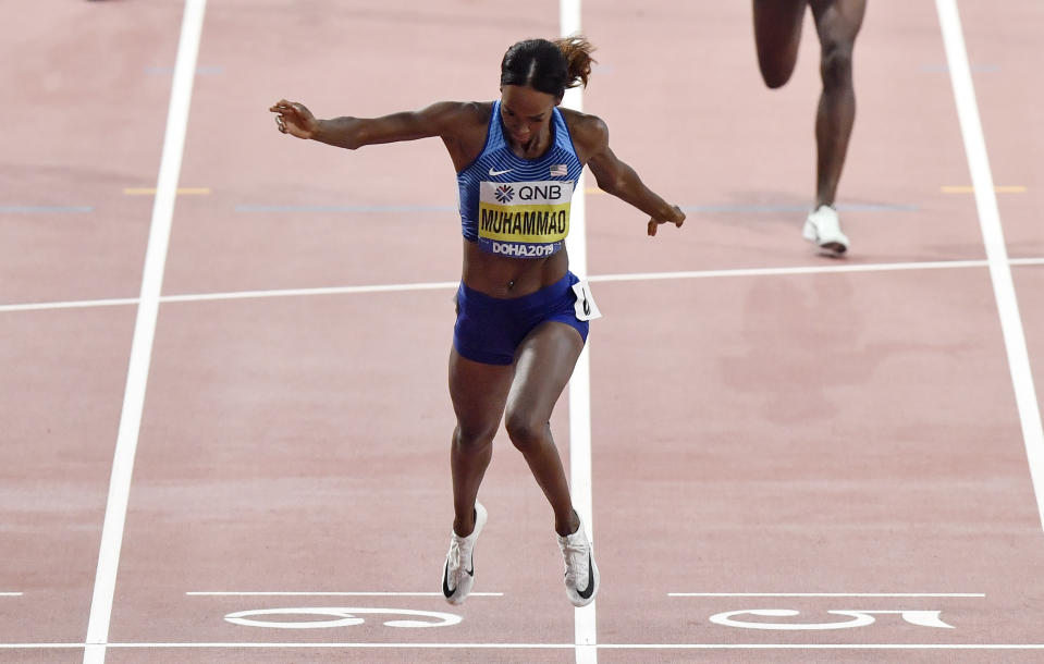 Gold medalist Dalilah Muhammad, of the United States, finishes in a new world record time in the the women's 400 meter hurdles final at the World Athletics Championships in Doha, Qatar, Friday, Oct. 4, 2019. (AP Photo/Martin Meissner)