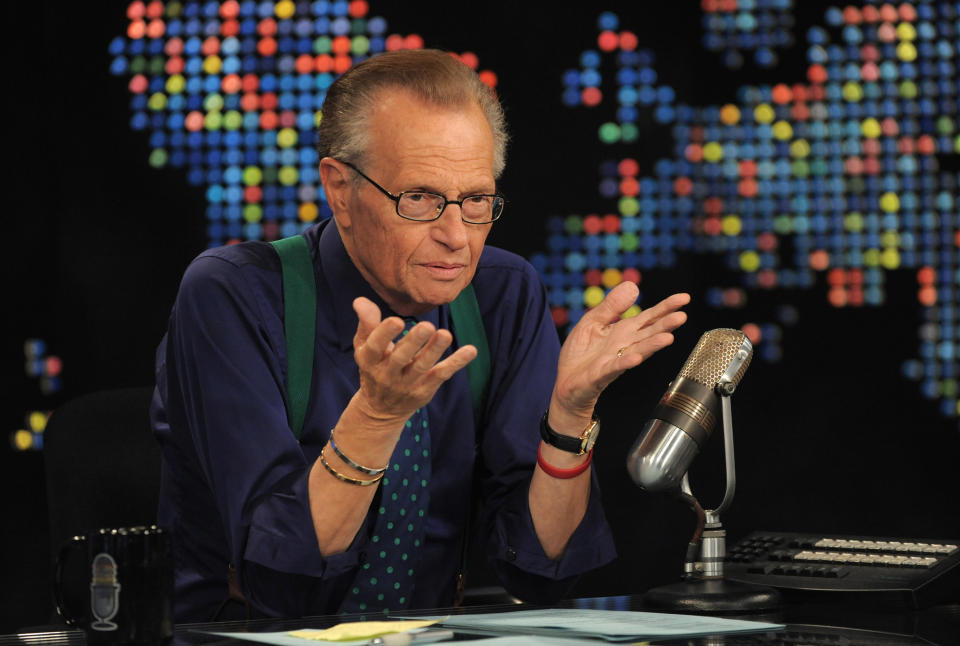 Larry King sitting in front of a microphone on his TV show