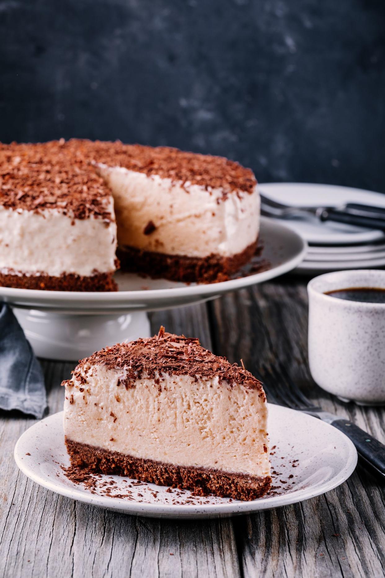 A piece of cold chocolate cheesecake on a plate on  wooden rustic background