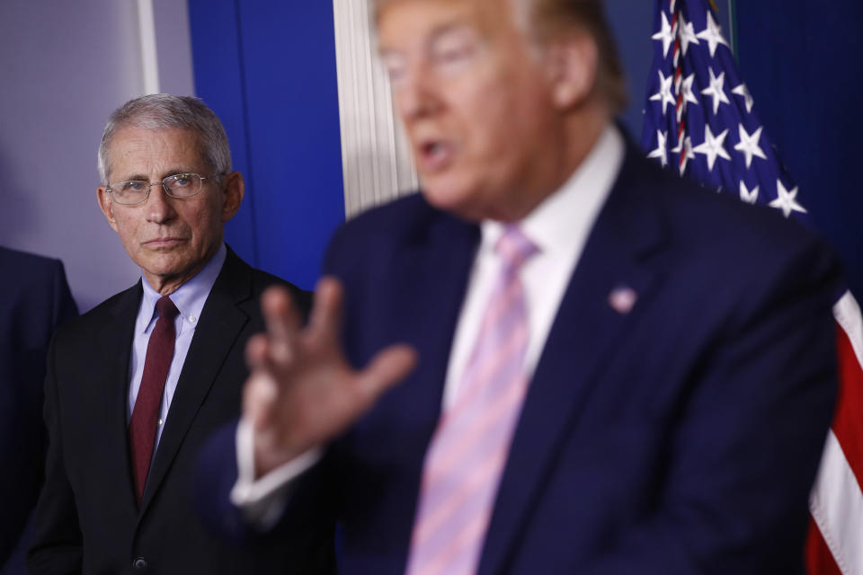 Dr. Anthony Fauci, director of the National Institute of Allergy and Infectious Diseases, left, listens as President Donald Trump speaks during a coronavirus task force briefing at the White House, April 4, in Washington. (Photo: (AP Photo/Patrick Semansky))