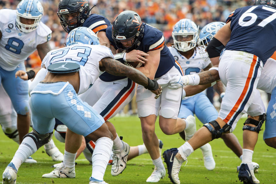 Virginia quarterback Brennan Armstrong (5) drives ahead for a touchdown run against North Carolina linebacker Power Echols (23) during the first half of an NCAA college football game on Saturday, Nov. 5, 2022, in Charlottesville, Va. (AP Photo/Mike Caudill)