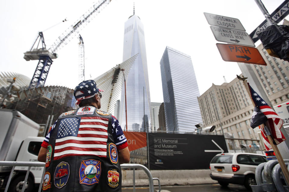 Jose Colon, of New York, looks up at 1 World Trade Center before a ceremony marking the 13th anniversary of the Sept. 11, 2001 attacks, Thursday, Sept. 11, 2014, in New York. (AP Photo/Jason DeCrow)