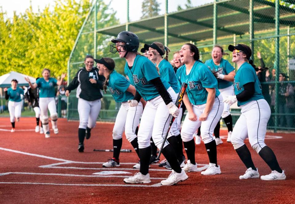 Bonney Lake’s Alissa Hermansen, 16, cheers on her teammate Kyla Cross, 8, who scored after Bella Jones, 21, hit a home run in the seventh inning of the 3A state softball tournament quarterfinals at the Regional Athletic Complex on Friday, May 27, 2022 in Lacey, Wash. Bonney Lake defeated Peninsula 3-2 with a triple play in the seventh inning to win the quarterfinal game.