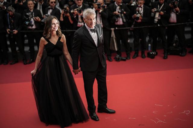 Calista Flockhart, left, and Harrison Ford pose for photographers upon arrival at the premiere of the film 'Indiana Jones and the Dial of Destiny' at the 76th international film festival, Cannes, southern France, Thursday, May 18, 2023. (AP Photo/Daniel Cole)