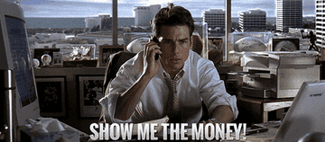 Tom Cruise yells "Show Me The Money" at a cluttered desk