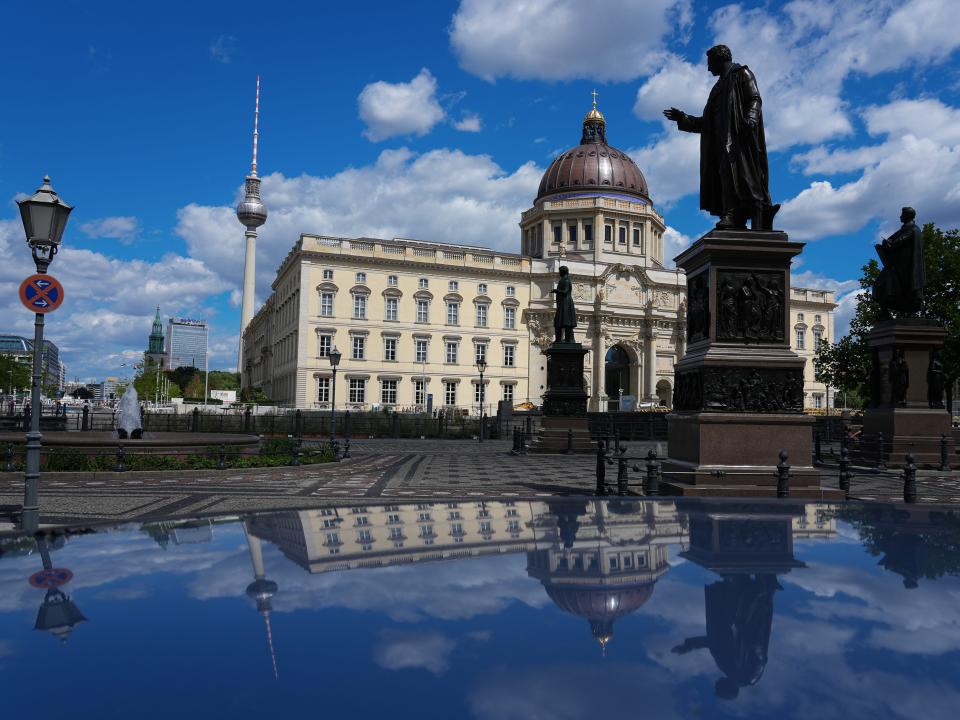 15 July 2022, Berlin: The TV Tower (l) and the City Palace with the Humboldt Forum are reflected in a car roof. In the foreground is the monument to Albrecht Thaer (1752-1828). The laying of the foundation stone for the new building with three baroque facades of the old Berlin Palace took place on June 12, 2013. The Humboldt Forum was opened on 16.12.2020. Photo: Soeren Stache/dpa (Photo by Soeren Stache/picture alliance via Getty Images)