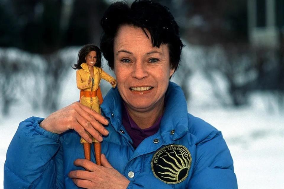 Stuntwoman Kitty O'Neil holds her action figure made by Mattel.