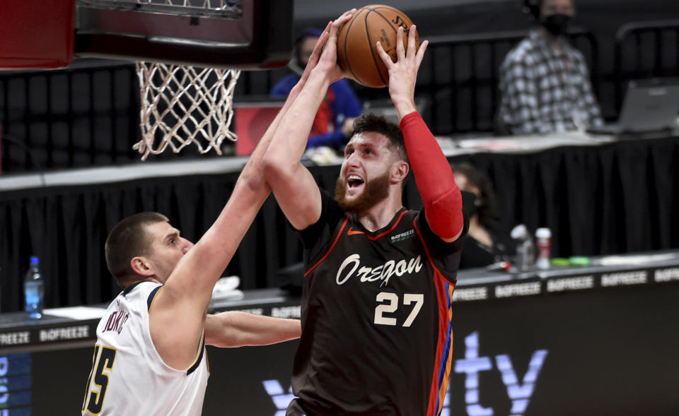 Portland Trail Blazers center Jusuf Nurkic, right, is fouled by Denver Nuggets center Nikola Jokic, left, as he drives to the basket during the first half of an NBA basketball game in Portland, Ore., Sunday, May 16, 2021. (AP Photo/Steve Dykes)