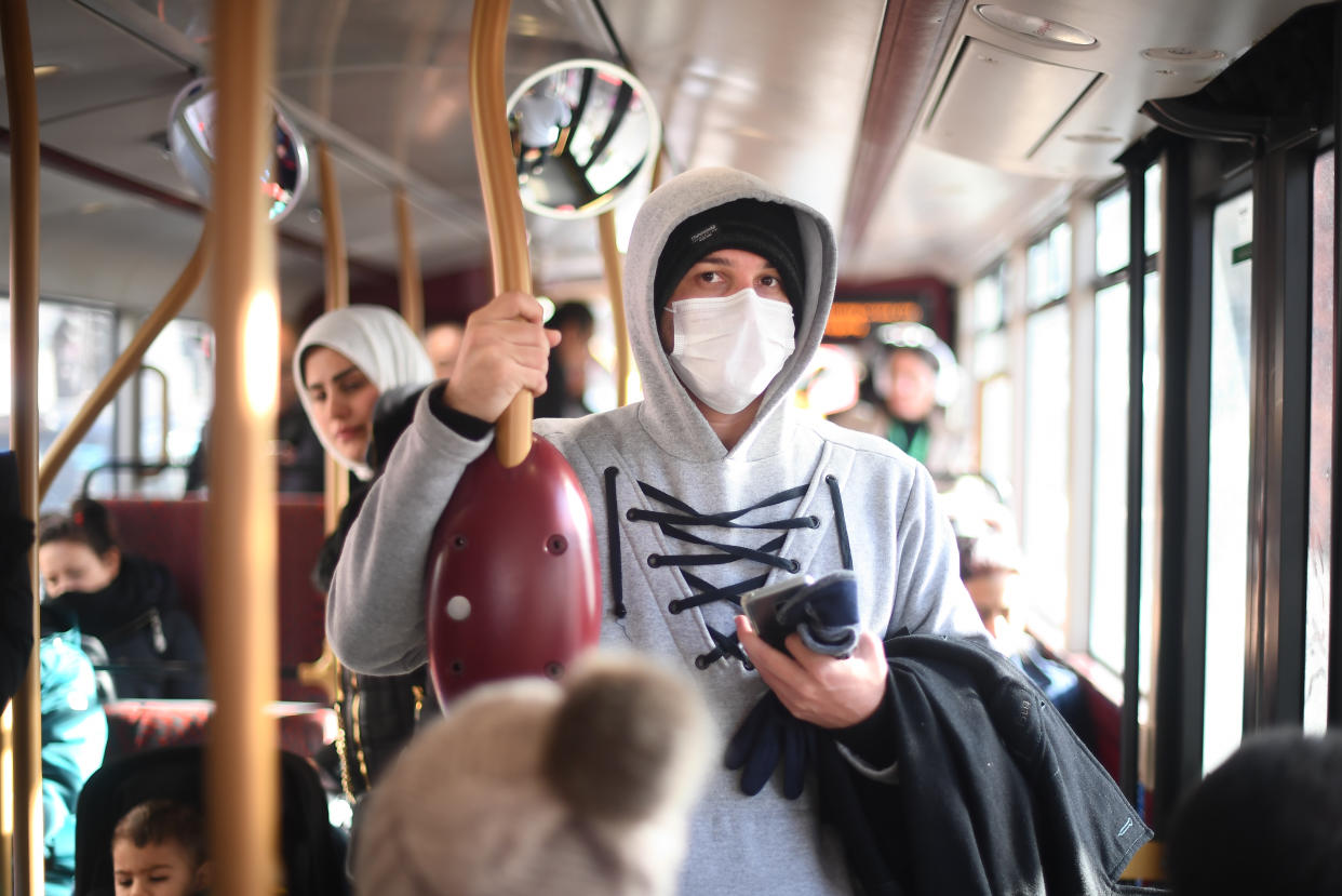 A pedestrian wears a protective facemask while taking a bus in Westminster, London, on the day that Health Secretary Matt Hancock said that the number of people diagnosed with coronavirus in the UK has risen to 51. (Photo by Victoria Jones/PA Images via Getty Images)