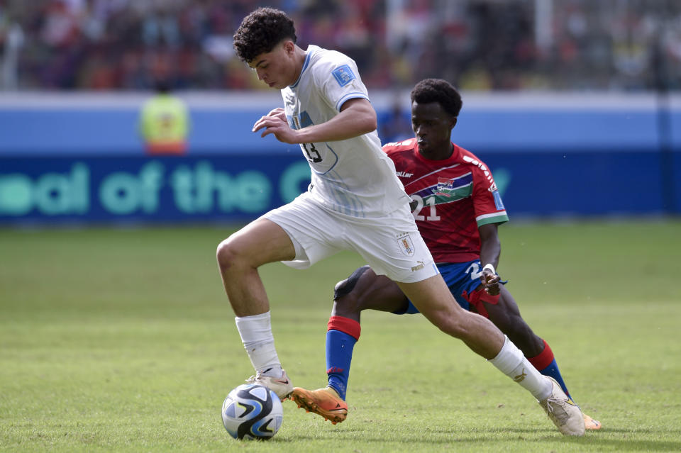 Mamin Sanyang de Gambia persigue a Alan Matturro de Uruguay durante el partido de octavos de final del Mundial Sub20 en el estadio Madre de Ciudades de Santiago del Estero, Argentina, jueves 1 junio, 2023. (AP Foto/Gustavo Garello)