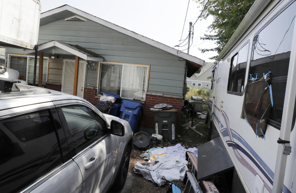 FILE - In this July 31, 2019, file photo, vehicles are parked outside the home of Paige A. Thompson, who uses the online handle "erratic," in Seattle. Thompson, 33, was arrested and charged with accessing personal information of 106 million Capital One credit card holders. Thompson's former roommate has been sentenced to four years in prison for illegally possessing firearms, according to federal prosecutors. Park Quan, 67, was sentenced Wednesday, Oct. 14, 2020, in U.S. District Court in Seattle after pleading guilty to being a felon in possession of guns, according to U.S. Attorney Brian Moran. (AP Photo/Ted S. Warren, File)