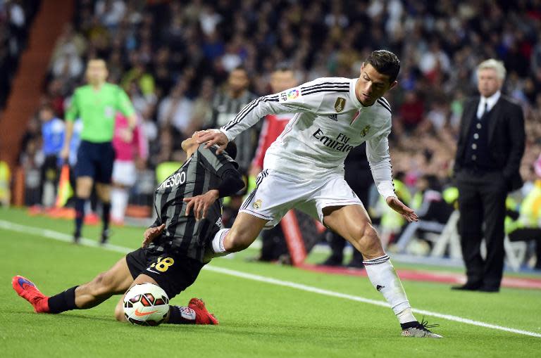 Real Madrid's Portuguese forward Cristiano Ronaldo (R) vies with Malaga's Venezuelan defender Roberto Jose Rosales during the Spanish league football match Real Madrid CF vs Malaga FC in Madrid on April 18, 2015