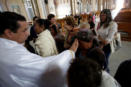 Priest Tomas Martinez blesses a woman whose son is missing, during a Mass for mothers of missing persons on Mother's Day in Chilapa de Alvarez, in the state of Guerrero, Mexico May 10, 2018. REUTERS/Daniel Becerril