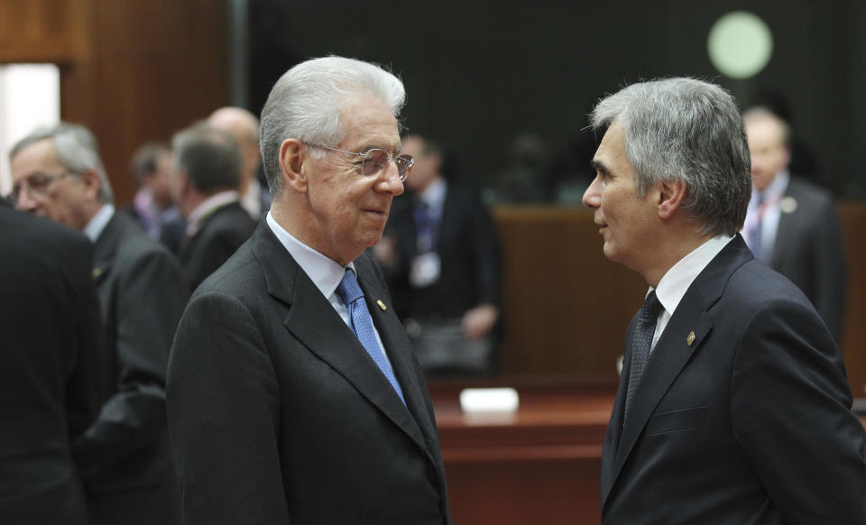 Italian Prime Minister Mario Monti, left, speaks with Austria's Chancellor Werner Faymann during a round table meeting at an EU summit in Brussels on Friday, Nov. 23, 2012. EU leaders begin what is expected to be a marathon summit on the budget for the years 2014-2020. The meeting could last through Saturday and break up with no result and lots of finger-pointing. (AP Photo/Yves Logghe)