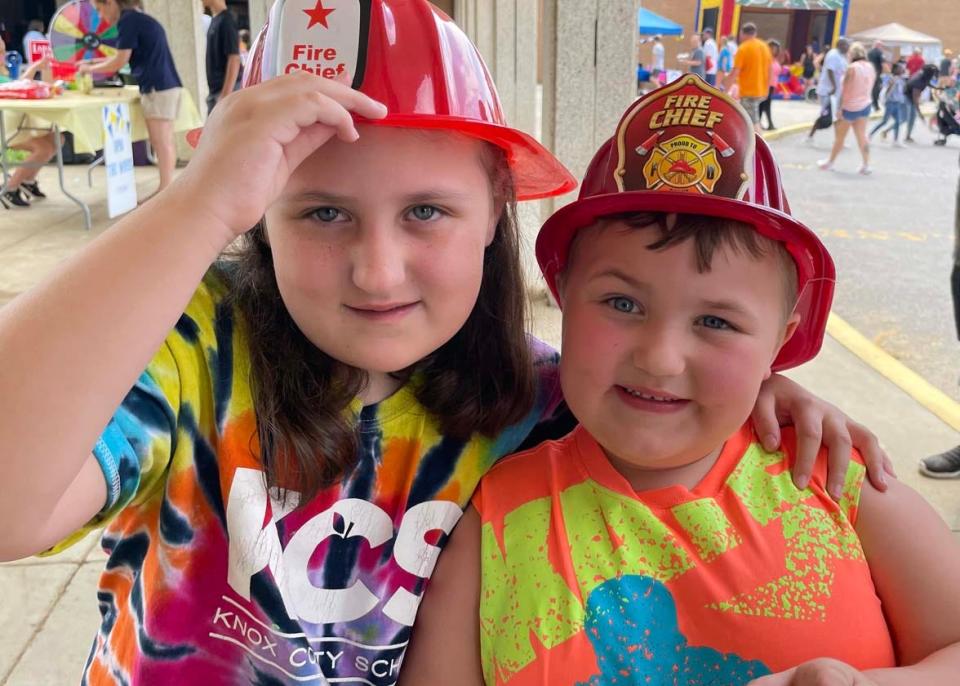 Joanie Gibbs, 6, and Abraham Gibbs, 5, seem to like the hats they received from the firefighters. Karns Community Fair at Karns High School Saturday, July 16, 2022