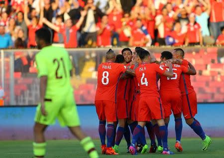 Jugadores de la selección chilena celebran uno de los goles convertidos a Venezuela en el Estadio Monumental de Santiago, Chile, Marzo 28. - Chile venció el martes 3-1 a Venezuela con un doblete del delantero Esteban Paredes y retornó a puestos de clasificación directa para el Mundial a falta de cuatro fechas para el término de las eliminatorias. REUTERS/Ivan Alvarado