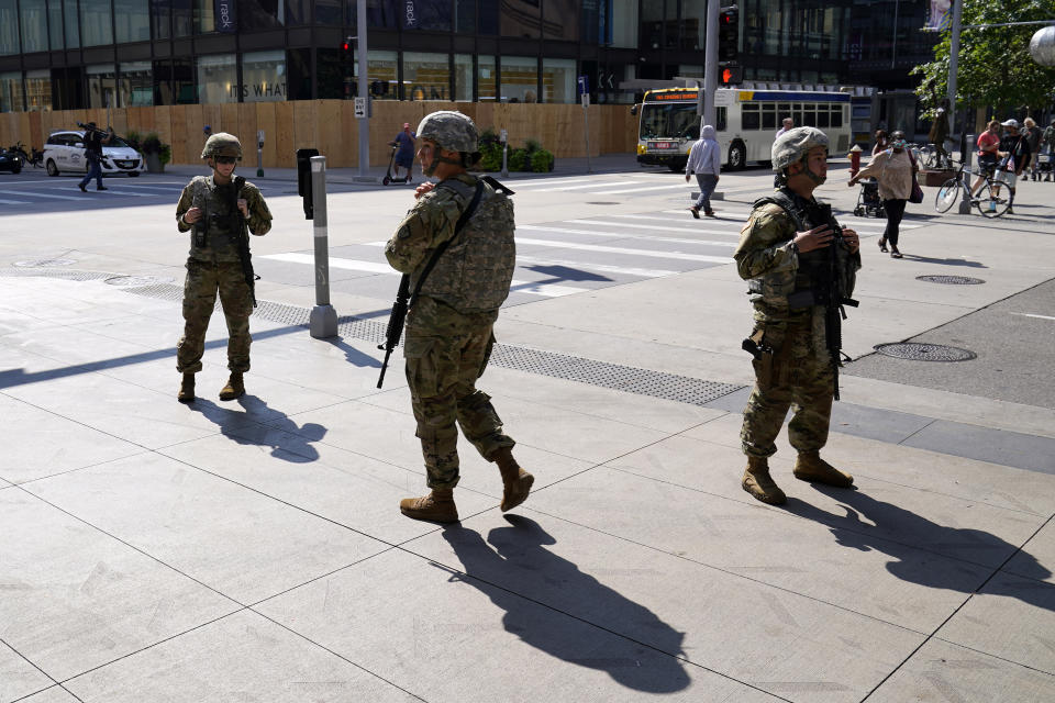 Minnesota National Guard soldiers stand watch along the famous Nicollet Mall Thursday, Aug. 27, 2020, in downtown Minneapolis. An emergency curfew expired and downtown Minneapolis was calm Thursday morning after a night of unrest that broke out following what authorities said was misinformation about the suicide of a Black homicide suspect. (AP Photo/Jim Mone)