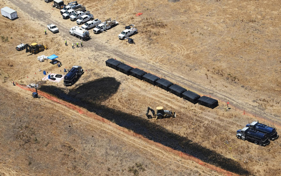 FILE - Clean-up workers monitor the source of an oil pipeline break near Refugio State Beach, north of Goleta, Calif., on May 20, 2015. The owner of an oil pipeline that spewed thousands of barrels of crude oil onto Southern California beaches in 2015 has agreed to pay $230 million to settle a class-action lawsuit by fishermen and property owners. Houston-based Plains All American Pipeline agreed to pay $184 million to fishermen and $46 million to property owners in the settlement reached Friday, May 13, 2022, with coastal property owners, fishermen and fish processors. (AP Photo/Michael A. Mariant, File)