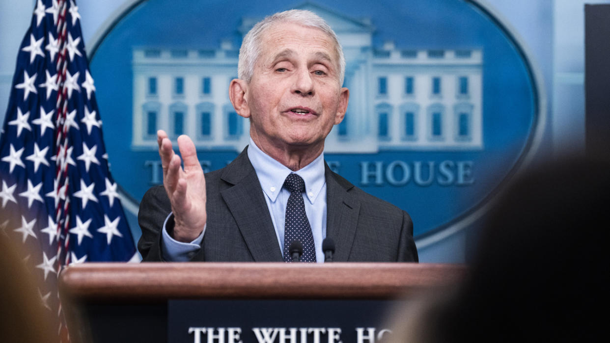 Dr. Anthony Fauci at the podium in the White House press briefing room, with the White House seal behind him.