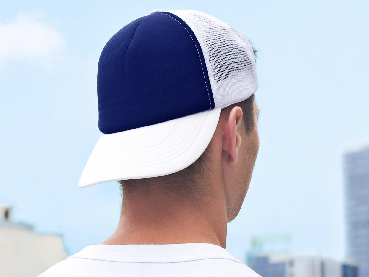 back of someone's head who's wearing a white and navy baseball hat