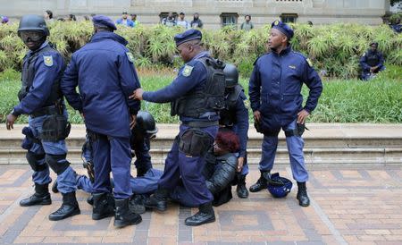 South African police protect their injured colleague during clashes with students at Johannesburg's University of the Witwatersrand, South Africa. REUTERS/Siphiwe Sibeko